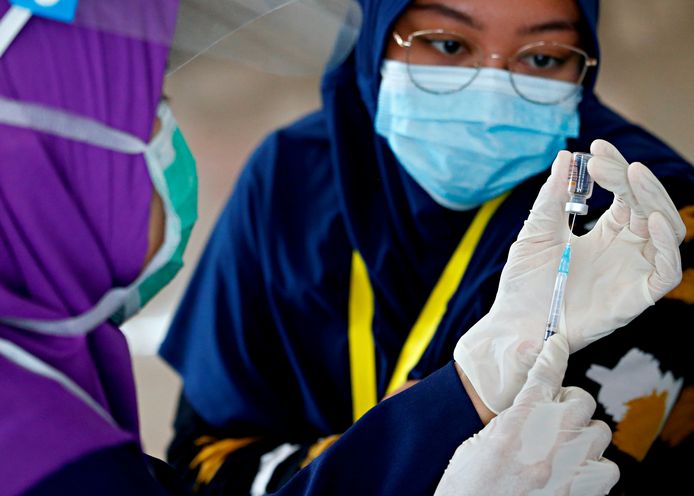 Een verpleegster bereidt een vaccin voor.