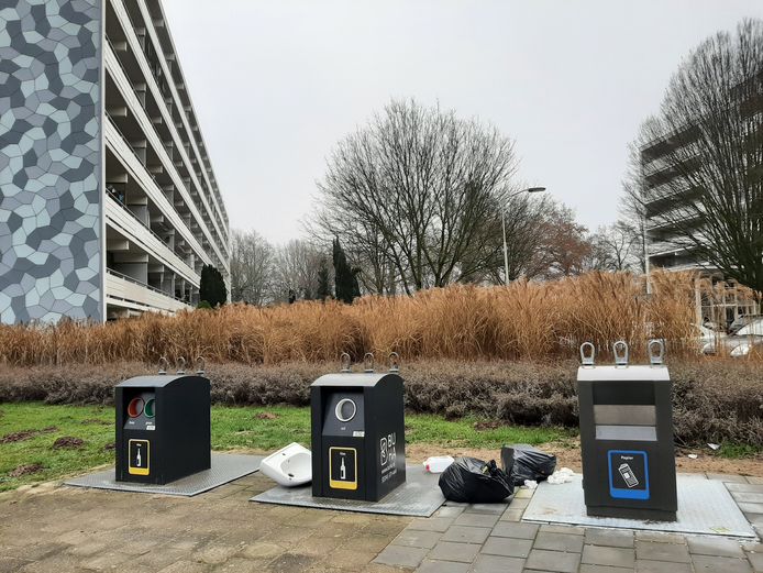Vuilniszakken met restafval bij de afvalcontainers tussen twee flats aan de Caenstraat in Doetinchem.