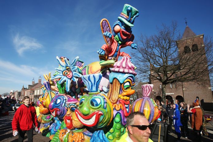 Optocht door Snerkersdurp, kleurrijke wagens in de Hoofdstraat ter hoogte van de Bartholomeus Kerk.