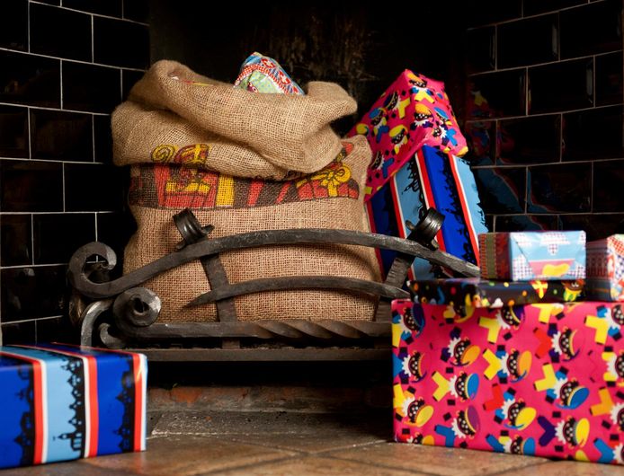 Een juten zak met cadeautjes van Sinterklaas in de open haard