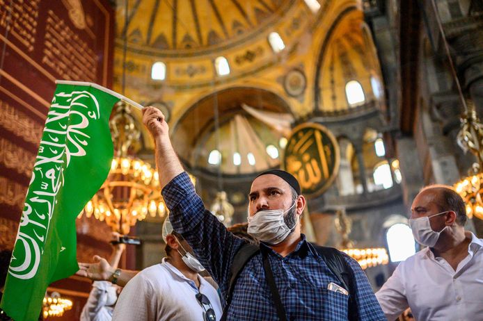 Een bezoeker met een islamitische vlag bezoekt de Hagia Sophia na afloop van het vrijdaggebed.