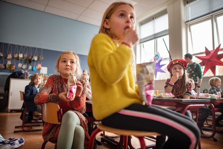 Leerlingen van groep 4 van een basisschool in Abcoude bekijken in december filmpjes over de kerstviering.  Beeld Guus Dubbelman / de Volkskrant