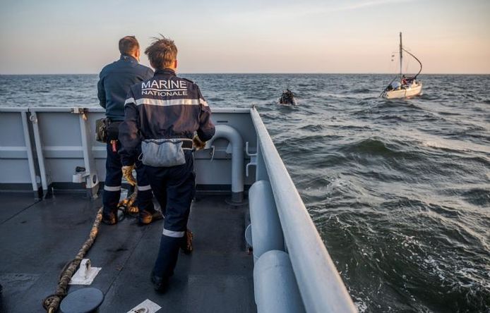 Het Franse marineschip vlakbij de zeilboot.