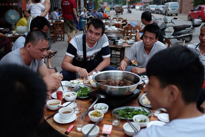 Mensen eten hondenvlees in een restaurant in Yulin.