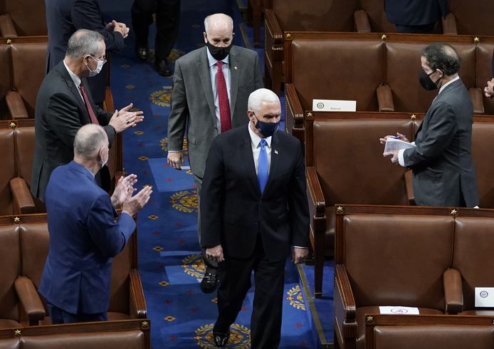 Vice-president Mike Pence ontvangt applaus wanneer hij na de bestorming terug de zaal in wandelt om de vergadering te hervatten.