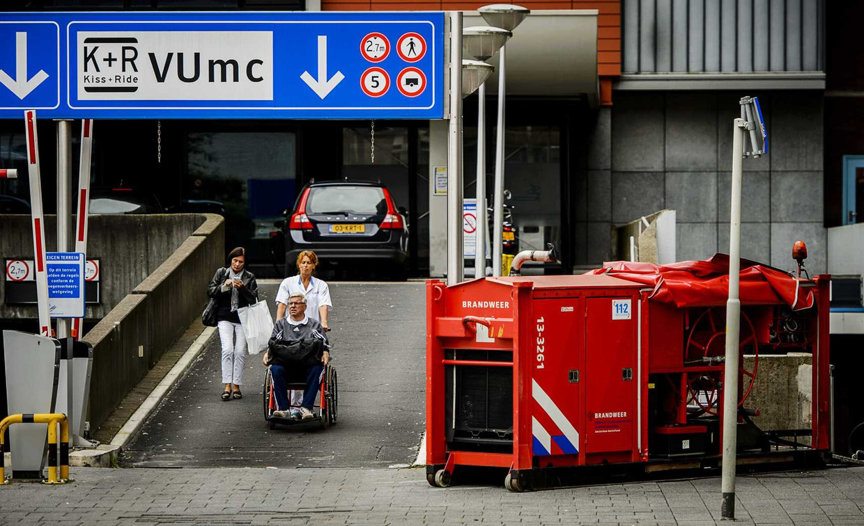 Een medewerkster van het ziekenhuis evacueert een patiënt. Beeld anp