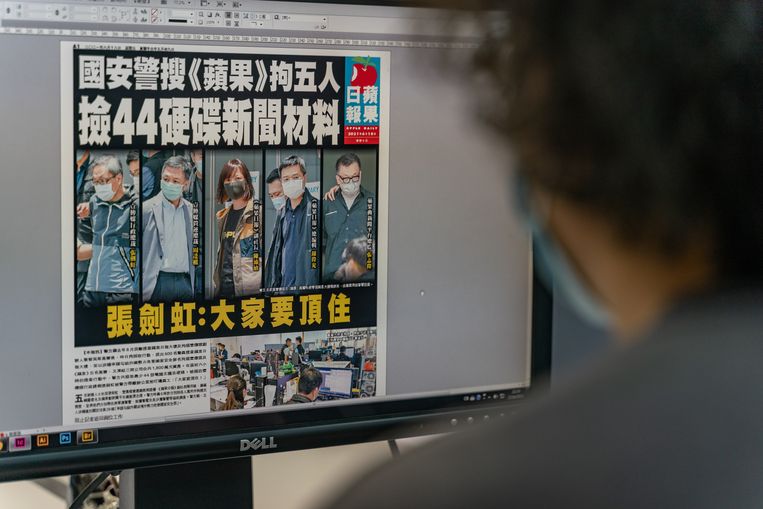 Editor en jefe del Apple Daily con la portada del periódico del viernes en su pantalla, mostrando imágenes de los cinco ejecutivos arrestados.  Imagen Getty Images