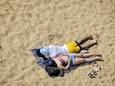 Zonaanbidders op het strand van Scheveningen genieten tijdens een warme lentedag.