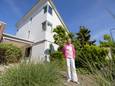 Saskia Woudstra voor haar houten huis.