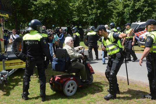 Politie communiceert met oudere vrouw op het Malieveld.
