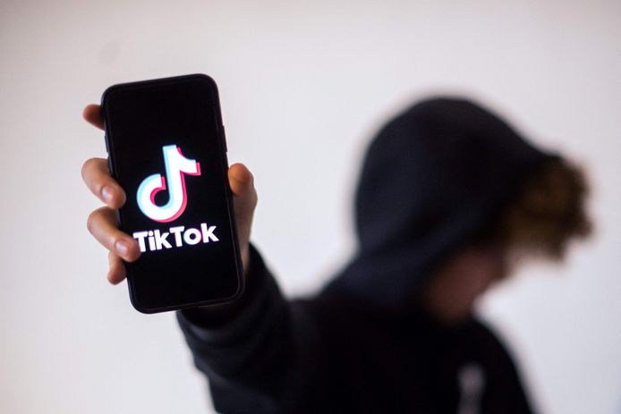 Een tiener toont het logo van de app TikTok.