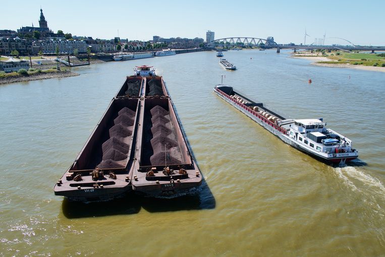 Steenkool wordt per boot vervoerd over de Waal, hier bij Nijmegen.  Beeld Getty Images