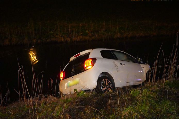 Bij het ongeluk belandde een witte auto in de sloot.