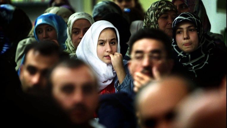 Een jonge vrouw bijt op haar nagels tijdens een van de toespraken van uniersiteitsbestuurders bij de opening van het nieuwe academische jaar van de Islamitische Universiteit in Rotterdam. Beeld ANP