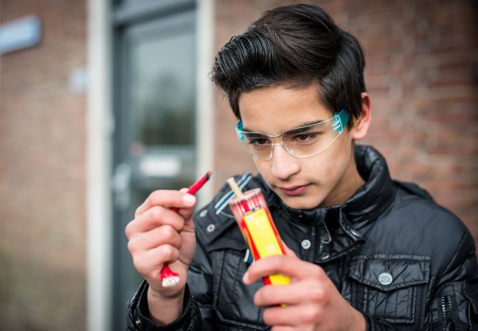 Een jongen steekt vuurwerk af op straat.