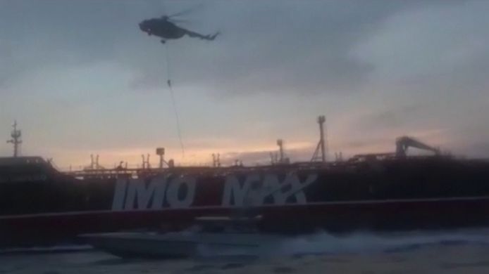 Leden van de garde laten zich uit een helikopter op het schip zakken