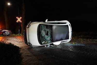 Vrouw kruipt door kapotte voorruit uit auto als die op zijkant belandt in Molenschot