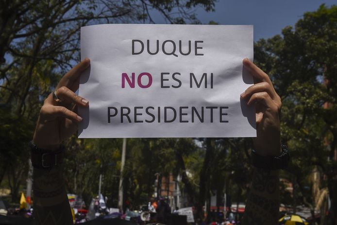 Duque werd in juni verkozen tot nieuwe president. Een van zijn voornaamste campagnepunten was de wijziging van het vredesakkoord met de FARC. Hoewel het internationaal wordt bejubeld, is het verdrag in Colombia zelf omstreden. Duque vindt dat de regering te veel toegevingen heeft gedaan aan de guerillero's en heeft meteen correcties aangekondigd. Dat valt niet bij iedereen in de smaak. Op het bord staat 'Duque is niet mijn president'.