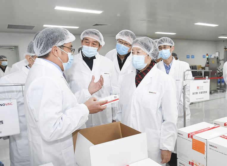 Chinese bestuurders op inspectie bij Sinovac Biotech in Beijing, waar een vaccin tegen covid-19 wordt ontwikkeld en geproduceerd.  Beeld EPA