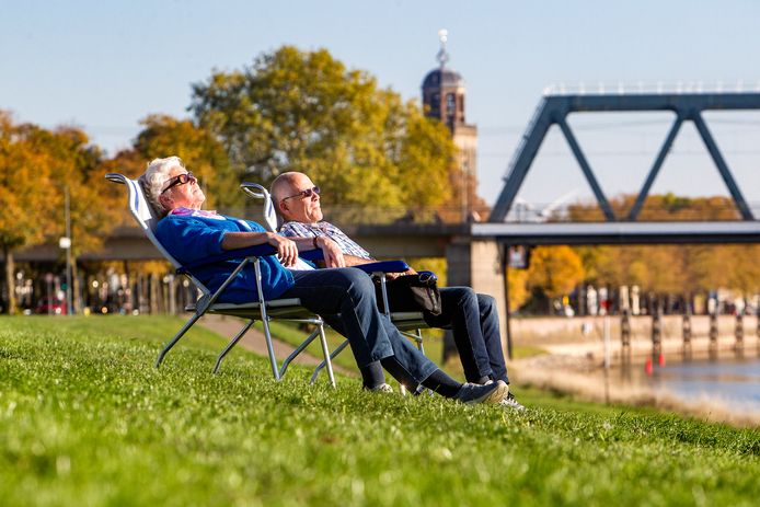 13 oktober 2018 en het is zomers warm. Zonaanbidders genieten in Deventer langs de IJssel.