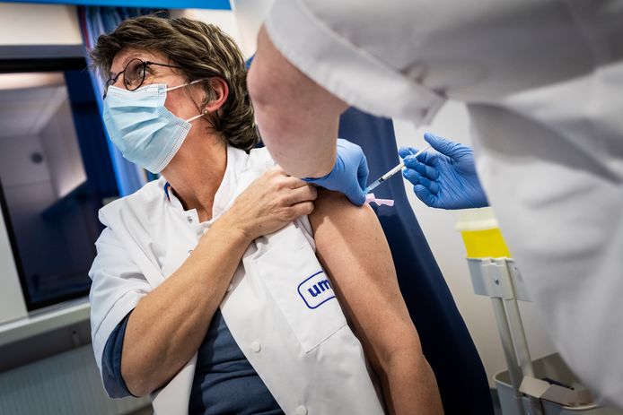 Een medewerker van het UMCG-ziekenhuis in Groningen krijgt een vaccin toegediend.