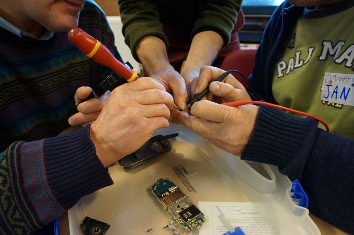 Vrijwilligers werken samen om defecte apparaten te herstellen.