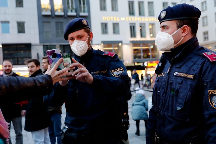 Oostenrijkse agenten checken de vaccinatiebewijzen van bezoekers van een kerstmarkt in Wenen.