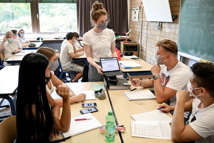 Leerlingen en de lerares dragen mondkapjes bij de start van het nieuwe schooljaar in Duitsland.