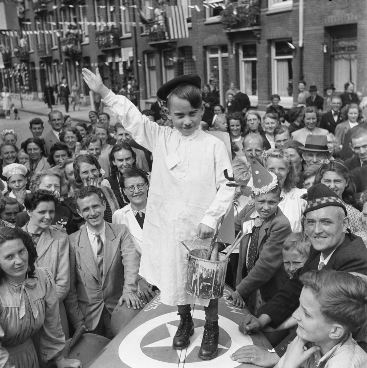Op een bij een Amsterdams bevrijdingsfeest gemaakte foto is een jongetje verkleed als Hitler. De samenstellers van Adolf Hitler: De beeldbiografie zouden graag weten waar deze foto werd gemaakt.  Beeld Anefo/Nationaal Fotoarchief