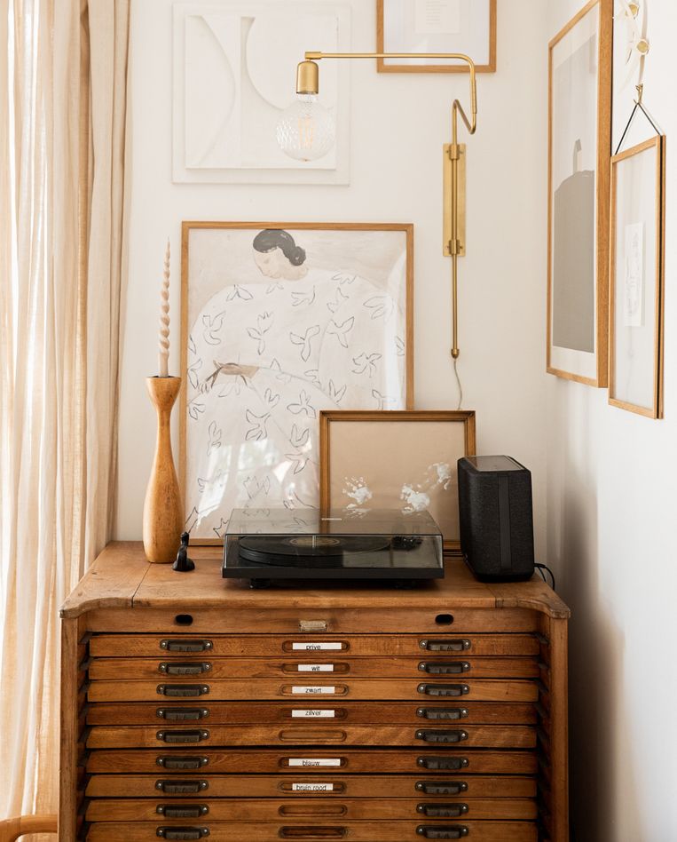 Ladekast Marktplaats, posters PSTR Studio, 3D-kunstwerk en handjes van Koosje zelfgemaakt, klein houten kunstwerk Ruben van der Scheer, kandelaar van kringloopwinkel, wandlamp House Doctor, platenspeler Pro-Ject, speaker Denon. Beeld Beeld vtwonen 09-2022 | styling Ilona Jongepier | fotografie Diana van leeuwen