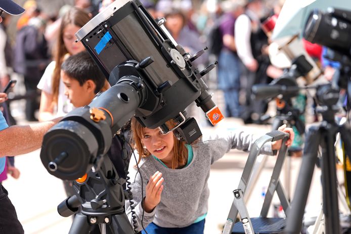 Een vrouw kijkt via een telescoop naar de zonsverduistering in Denver.