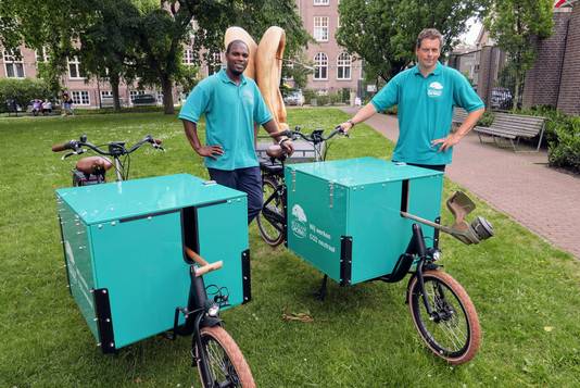 Christefer Frederica (links) en zijn werkgever Roel Jansen van Biggelaar Groen uit Den Dungen bij de nieuwe elektrische bakfietsen die het bedrijf in
zet.