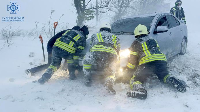 Hulpverleners bevrijden een auto uit de sneeuw in de regio Odessa.