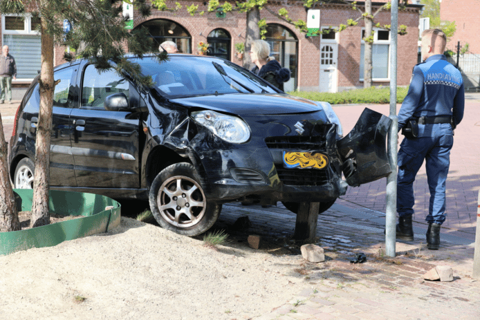 Een automobiliste belandde donderdagmiddag met haar auto bovenop twee houten palen in Loon op Zand.