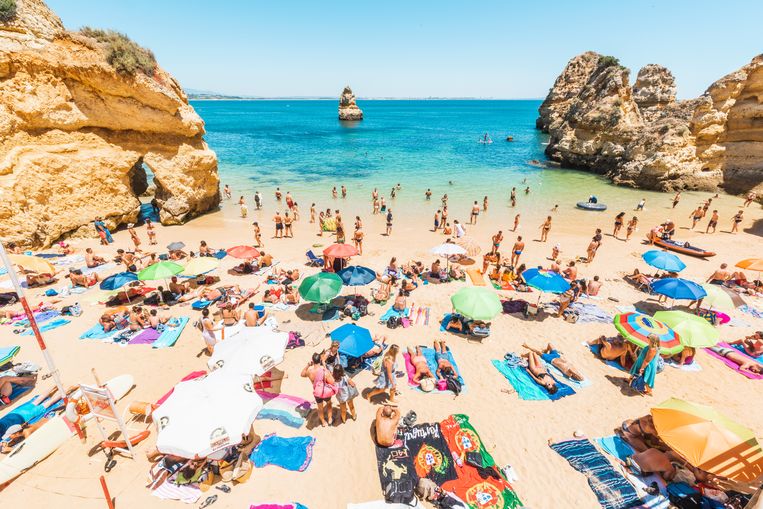 Toeristen genieten van de zon in de Algarve. Beeld Getty Images