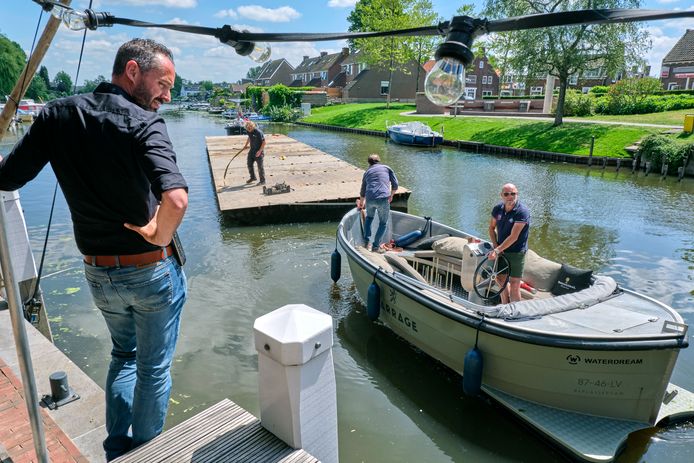 Horecamagnaat Bjorn van Dijl, met zonnebril op het bootje, vaart zelf het terrasvergrotende ponton naar Le Barrage in Alblasserdam. ,,Om het terras uit te breiden, konden we alleen het water op. Dus dat hebben we dan maar gedaan.