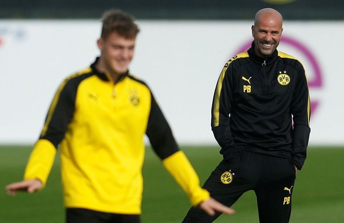 Peter Bosz kijkt lachend toe bij de training van Dortmund.