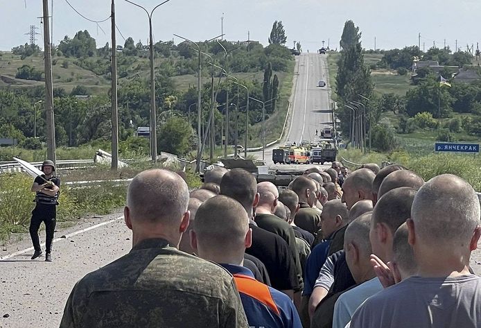 Des prisonniers de guerre ukrainiens libérés dans le cadre d'un échange de prisonniers avec la Russie, marchant vers le côté ukrainien dans un lieu tenu secret, le 29 juin 2022.