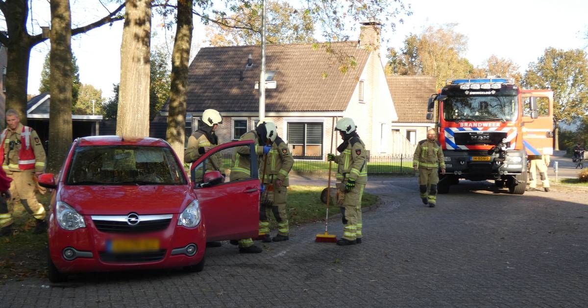 Auto op zijn kant aan de W Jaasmasingel in Dwingeloo, brandweer duwt hem weer op zijn wielen