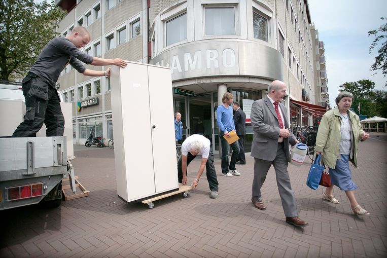 Verhuizers brengen Fortis-kasten binnen bij een kantoor van ABN Amro aan het Houtplein in Haarlem. Nadat de bank in 2008 in de problemen kwam, werd die gesplitst en in Nederland onderdeel van ABN Amro. 
 Beeld 