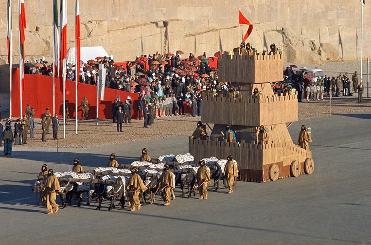 Een stoet soldaten verkleed als Perzische strijders trekt aan de internationale gasten voorbij. De praalwagen wordt getrokken door buffels.  Beeld Horst Faas / AP