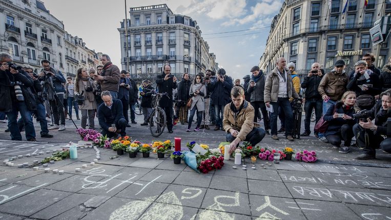 Op het Brusselse Beursplein worden met krijt leuzen en boodschappen van steun en liefde geschreven, bloemen neergelegd en kaarsen aangestoken. Hiermee tonen mensen hun solidariteit met de slachtoffers van de aanslagen in Brussel. Beeld anp