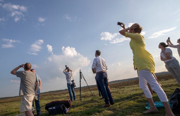 Wwethouder Leon Meijer en andere belangstellenden horen de Belevingsvlucht overkomen op de Ginkelse Heide.