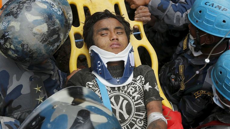 De 15-jarige Pema Lama wordt na vijf dagen levend onder het puin vandaan gehaald. Beeld reuters