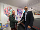 Jan Molenaar overhandigt de vier certificaten, behorend bij de kunstwerken van Viktoriia Kortashova, aan koper Ewout van Wijk.