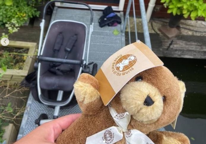 Troostbeertje van de politie met op de achtergrond de kinderwagen en de woonboot.