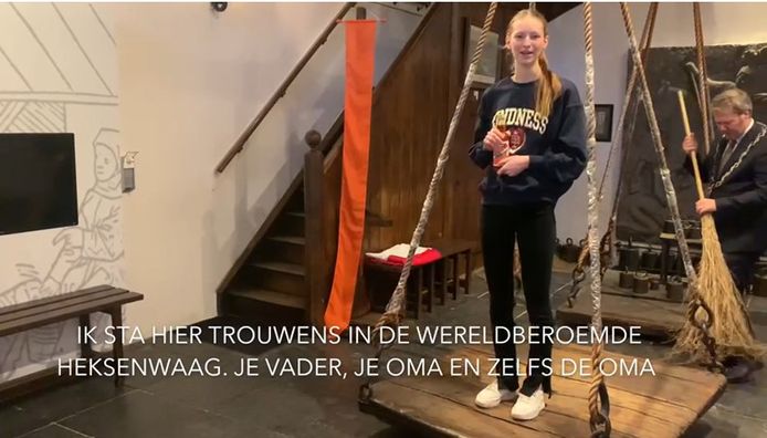 Leanne op de weegschaal in de Heksenwaag. Burgemeester Danny de Vries veegt op de achtergrond de vloer