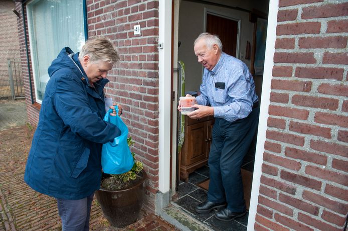 Vrijwilligster Sjan van Rooij overhandigt een maaltijd en soep aan Henk Kivits in Elshout.