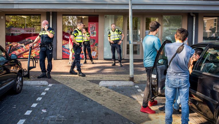 Politie bij de supermarkt in de wijk Poelenburg in Zaandam. Beeld Raymond Rutting / de Volkskrant
