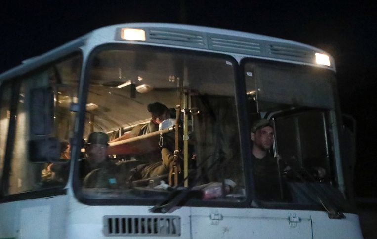 Een bus met daarin gewonde Oekraïense soldaten verlaat met een Russisch militair escorte het terrein van de Azovstal-fabriek in Marioepol. De Oekraïners worden naar een ziekenhuis gebracht in Novoazovsk, een stad in handen van Rusland. Beeld REUTERS